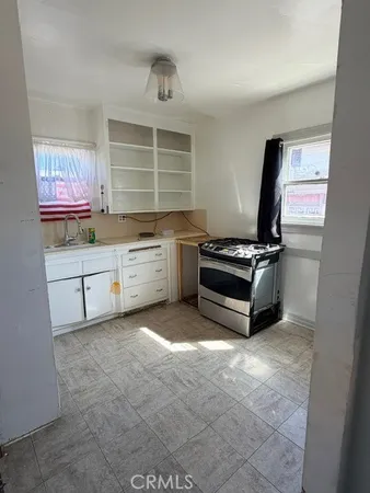 a kitchen with granite countertop a stove a sink and a refrigerator