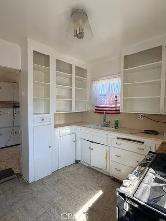 a room with a sink cabinets and wooden floor
