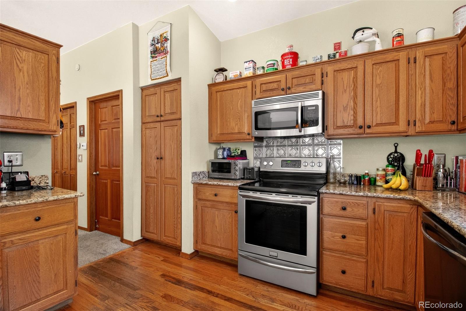 1445 Sutherland Road Manitou Springs, CO 80829 - Photo 16 of 43 a kitchen with stainless steel appliances granite countertop a stove top oven a refrigerator and a cabinets