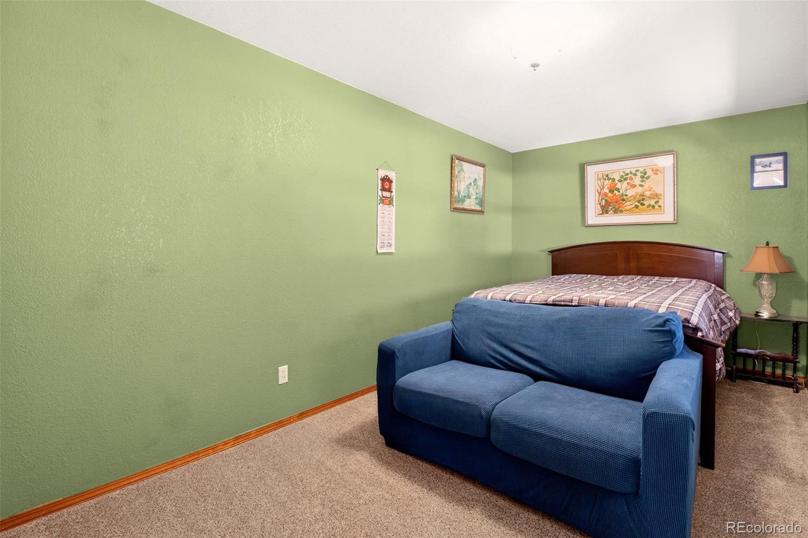 1445 Sutherland Road Manitou Springs, CO 80829 - Photo 28 of 43 a bedroom with a bed and a couch