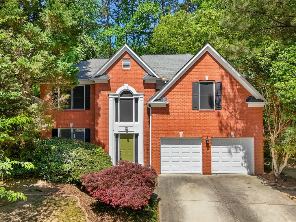 873 Red Rock Court Suwanee, GA 30024 - Photo 1 of 36 a front view of a house with a yard and garage