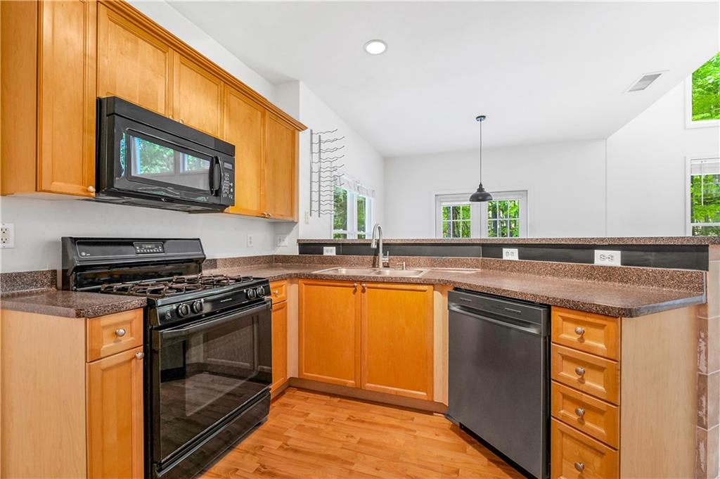 873 Red Rock Court Suwanee, GA 30024 - Photo 12 of 36 a kitchen with stainless steel appliances granite countertop stove a sink and a microwave