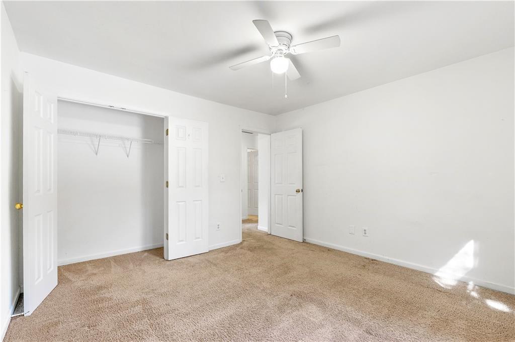 873 Red Rock Court Suwanee, GA 30024 - Photo 28 of 36 an empty room with a ceiling fan and a window