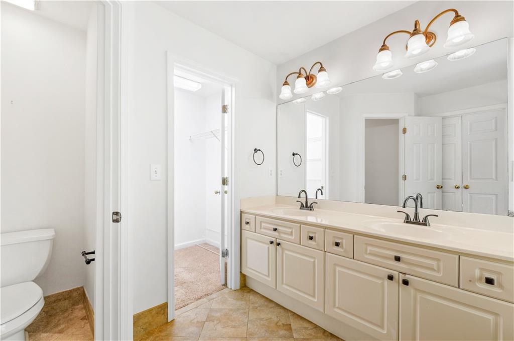 873 Red Rock Court Suwanee, GA 30024 - Photo 33 of 36 a bathroom with a sink a toilet and a mirror