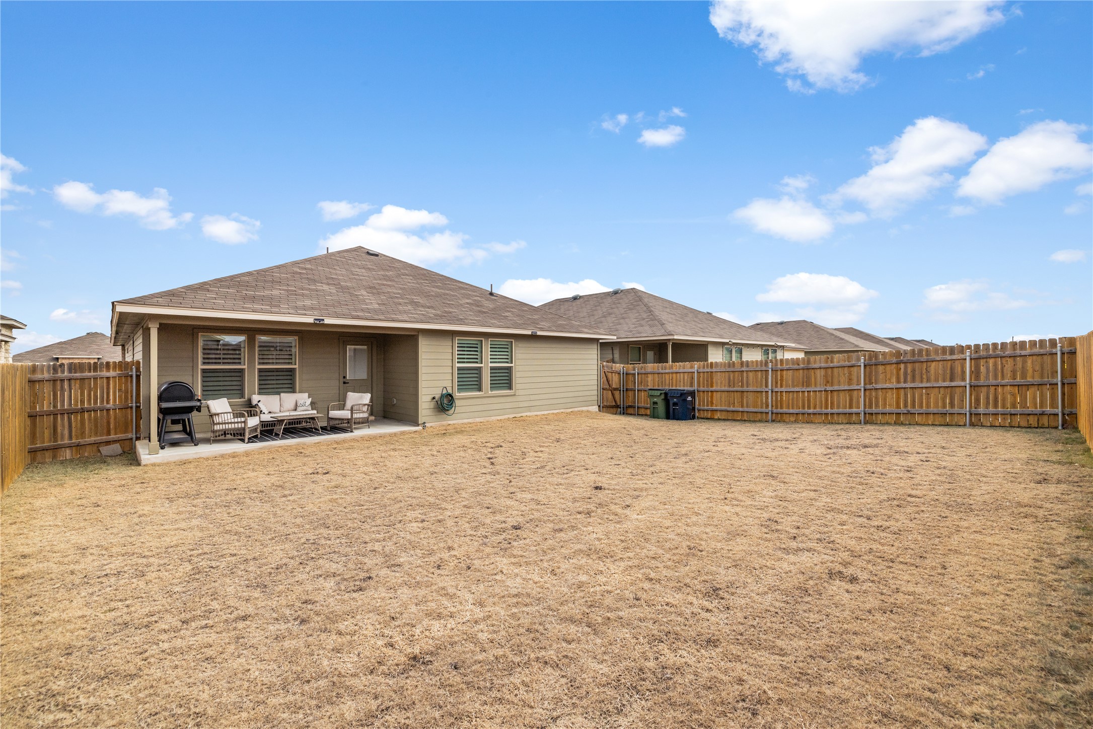 583 Taggart Trail Jarrell, TX 76537 - Photo 18 of 21 Back of house featuring a patio, outdoor lounge area, a fenced backyard, and a shingled roof