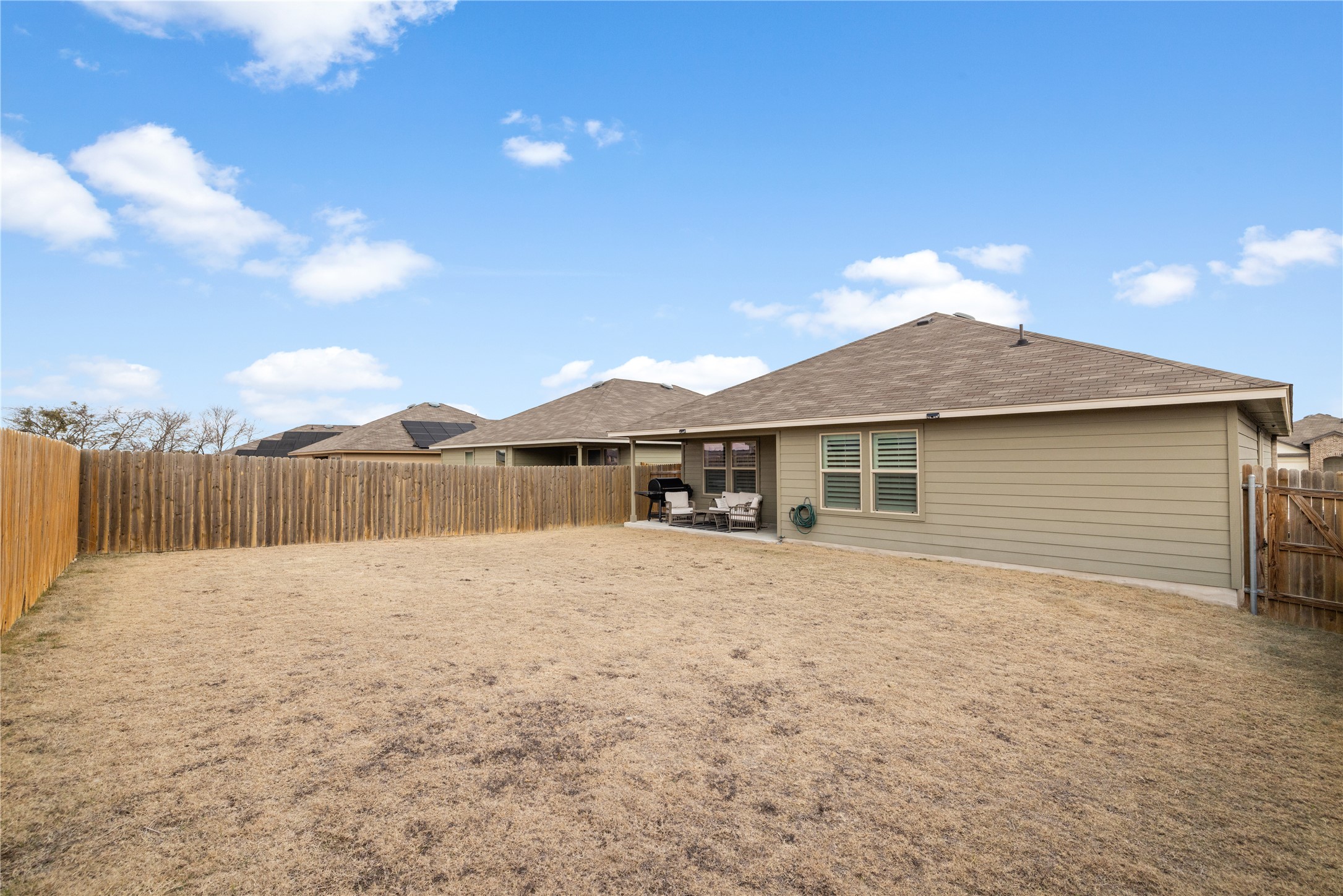 583 Taggart Trail Jarrell, TX 76537 - Photo 19 of 21 Back of house with a patio area, a fenced backyard, and roof with shingles