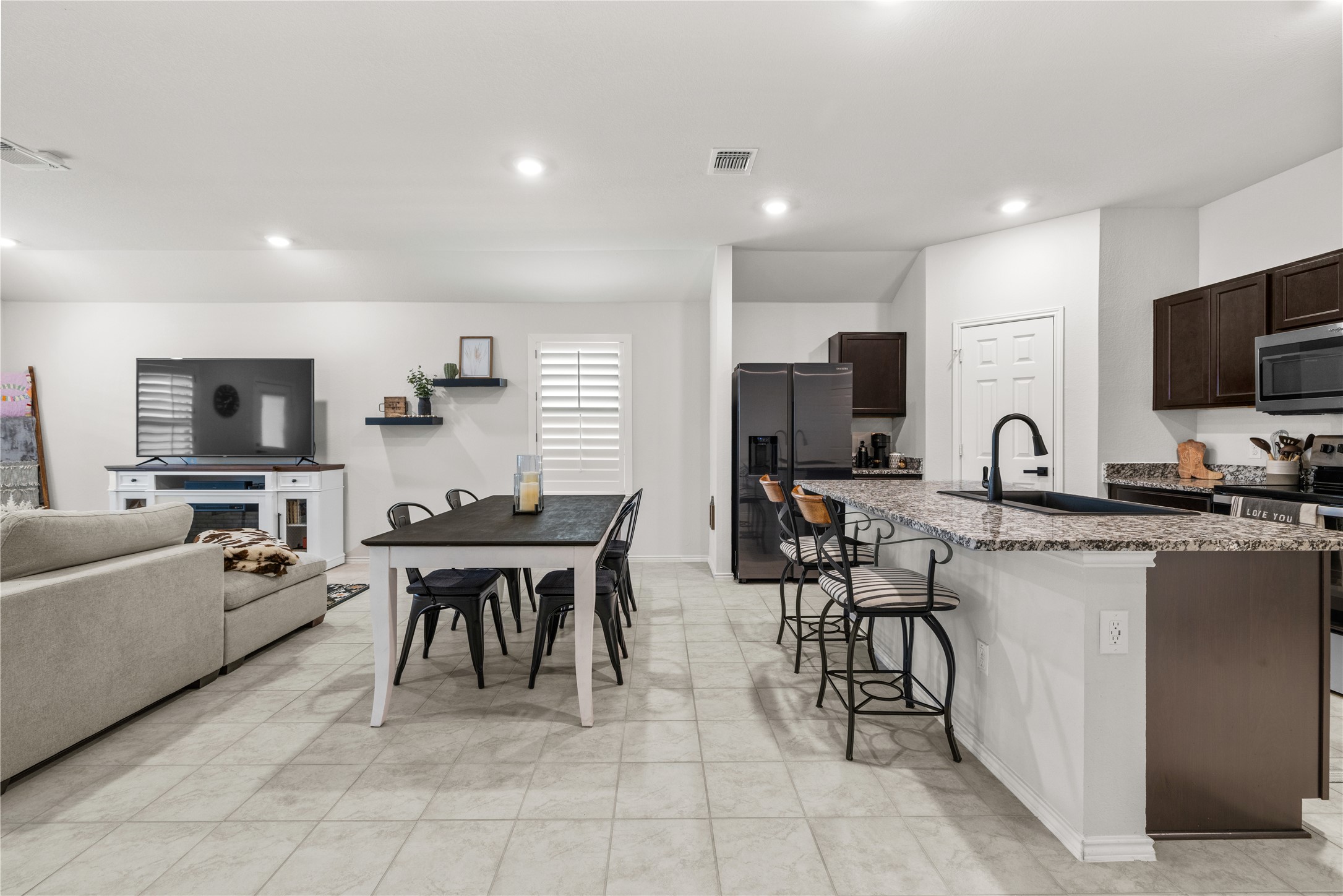 583 Taggart Trail Jarrell, TX 76537 - Photo 9 of 21 Kitchen featuring dark wood finish cabinets, a breakfast bar area, stainless steel appliances, a center island with sink, and recessed lighting