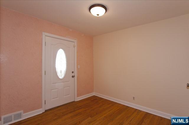 177 Magnolia Avenue Cresskill, NJ 07626 - Photo 13 of 15 an empty room with wooden floor and mirror
