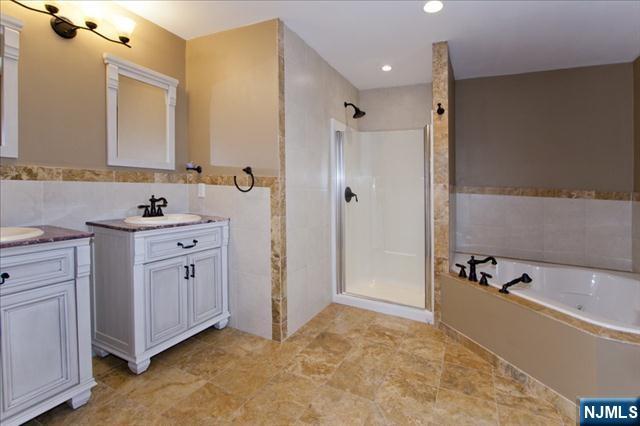 177 Magnolia Avenue Cresskill, NJ 07626 - Photo 10 of 15 a bathroom with a double vanity sink a mirror a bathtub and shower