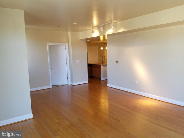 an empty room with wooden floor and entrance