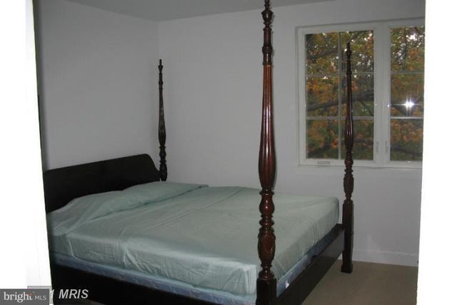 a bed sitting in a bedroom next to a window