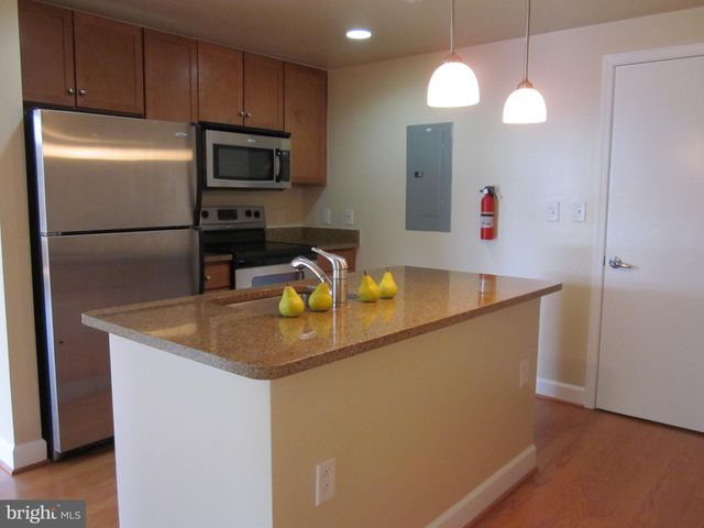 a kitchen with stainless steel appliances granite countertop a sink a refrigerator and a microwave