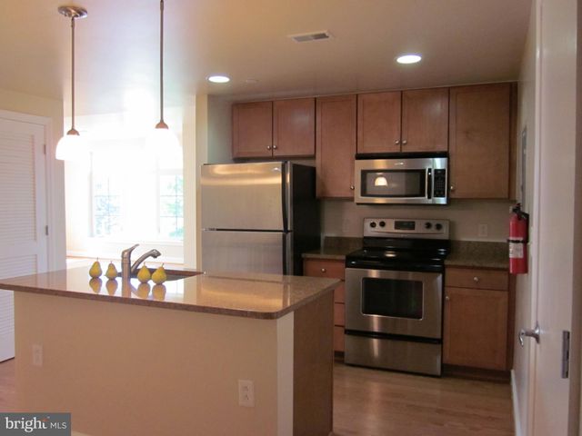 a kitchen with kitchen island a stove a sink and a refrigerator