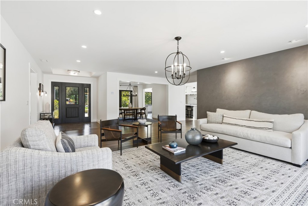24884 Jim Bridger Road Hidden Hills, CA 91302 - Photo 4 of 31 a living room with furniture a chandelier and a rug
