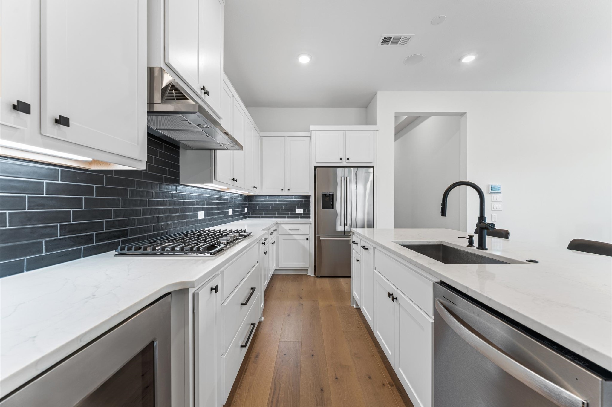 7327 Trial Rdg Drive Fulshear, TX 77441 - Photo 4 of 26 Sleek subway tile backsplash, deep farmhouse sink, and crisp white cabinetry — clean, classic, and easy to love every single day.