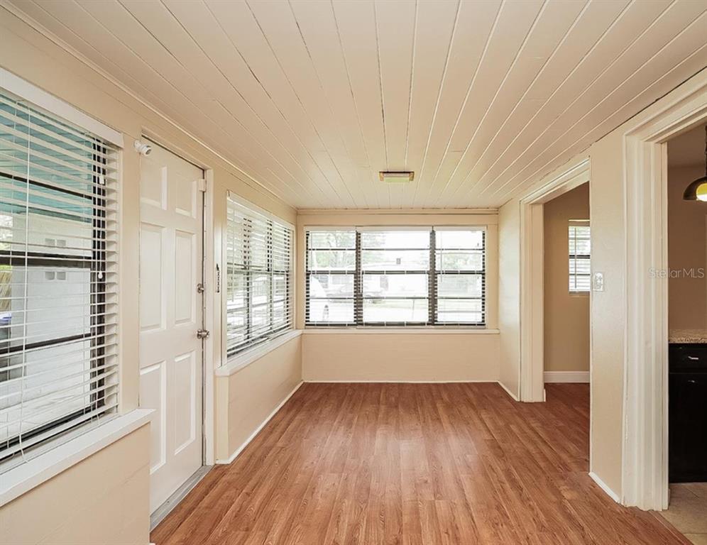 1203 Ferndell Road Orlando, FL 32808 - Photo 4 of 4 a view of an empty room with a window and wooden floor