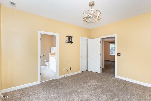 an empty room with closet and windows