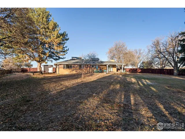 a view of residential houses with yard and trees