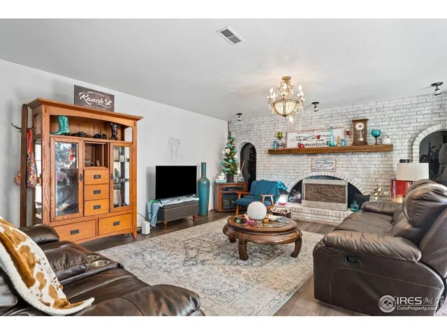 a living room with furniture a fireplace and flat screen tv