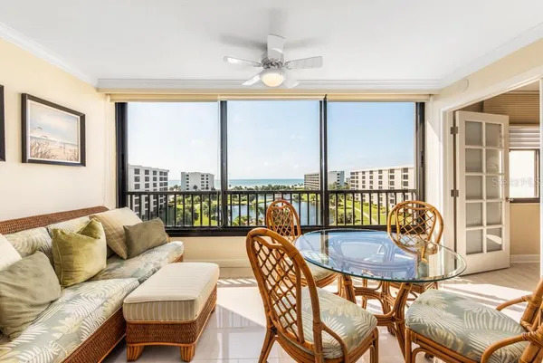a dining room with furniture and a floor to ceiling window