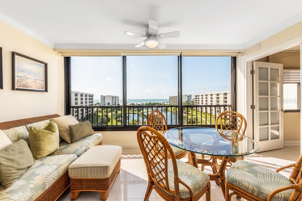 5770 Midnight Pass Road, Unit 605 Sarasota, FL 34242 - Photo 14 of 42 a dining room with furniture and a floor to ceiling window