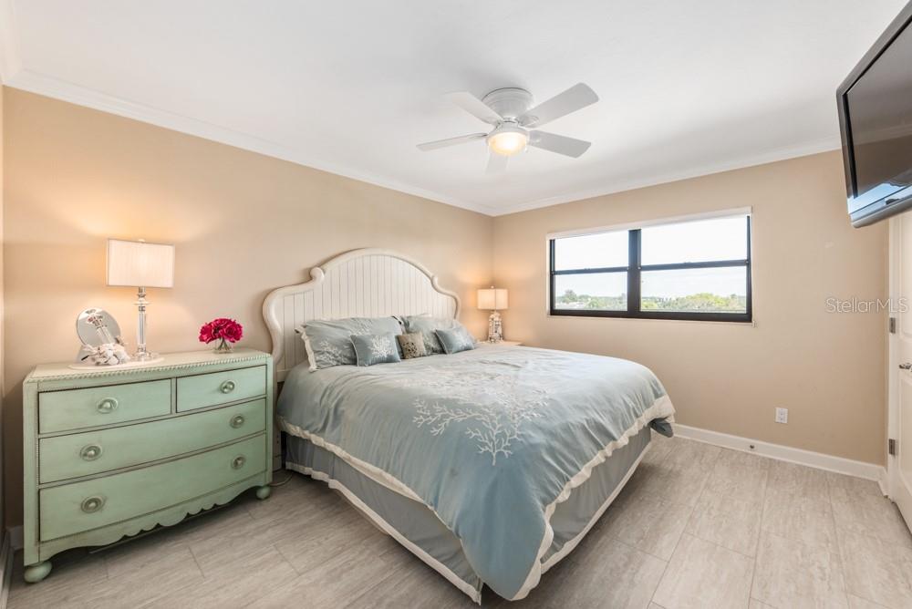 5770 Midnight Pass Road, Unit 605 Sarasota, FL 34242 - Photo 17 of 42 a bedroom with a bed and a chandelier