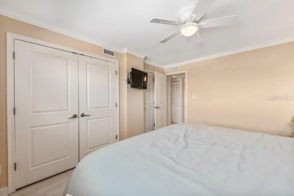 a view of a bedroom with a ceiling fan and a bathroom