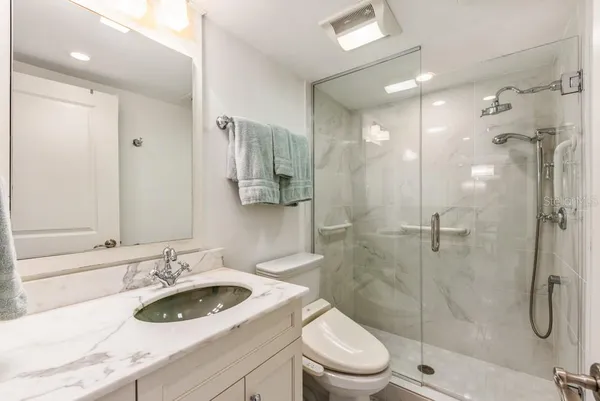 a bathroom with a sink a toilet and shower