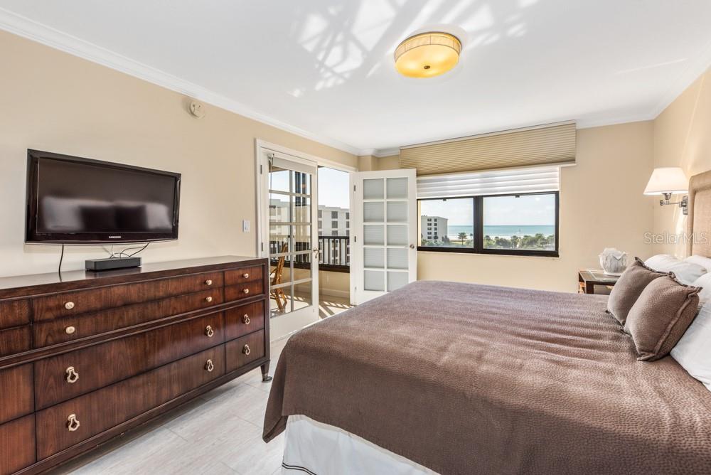 5770 Midnight Pass Road, Unit 605 Sarasota, FL 34242 - Photo 22 of 42 a bedroom with a bed and a flat screen tv