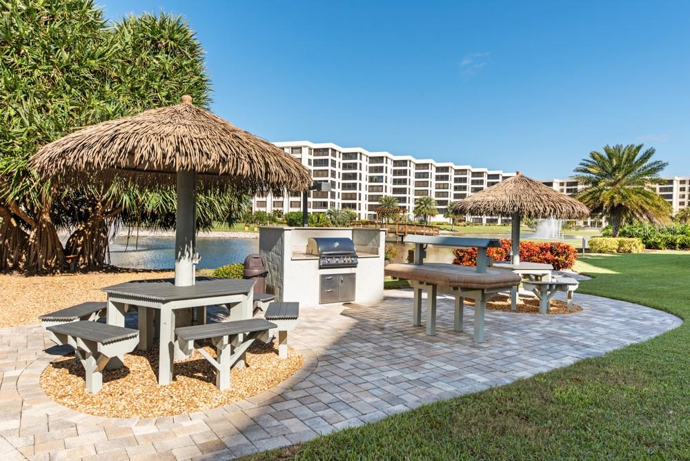 5770 Midnight Pass Road, Unit 605 Sarasota, FL 34242 - Photo 37 of 42 a view of a patio with a table and chairs under an umbrella