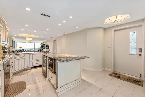 a kitchen with granite countertop white cabinets and white appliances