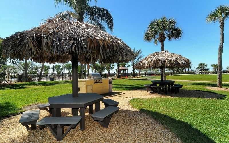 5770 Midnight Pass Road, Unit 605 Sarasota, FL 34242 - Photo 41 of 42 a view of a garden with a table and chairs under an umbrella