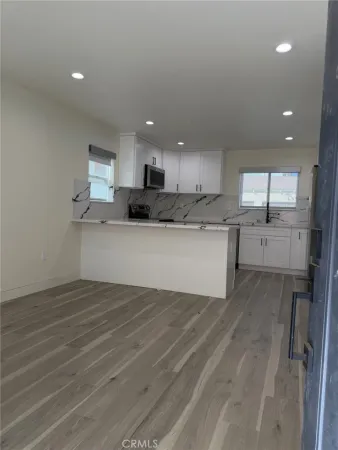 a view of a kitchen with a sink wooden cabinets and a window