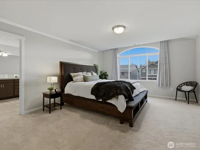 a bedroom with a bed and a large window