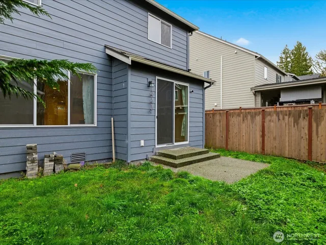 a view of backyard with potted plants and wooden fence