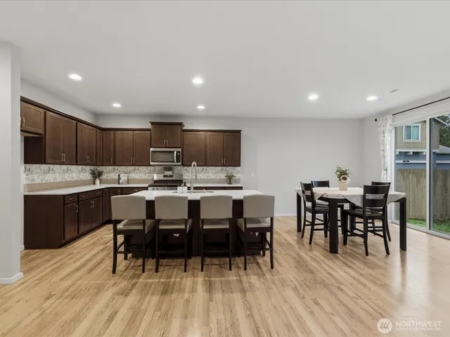 a view of kitchen with kitchen island dining table and stainless steel appliances