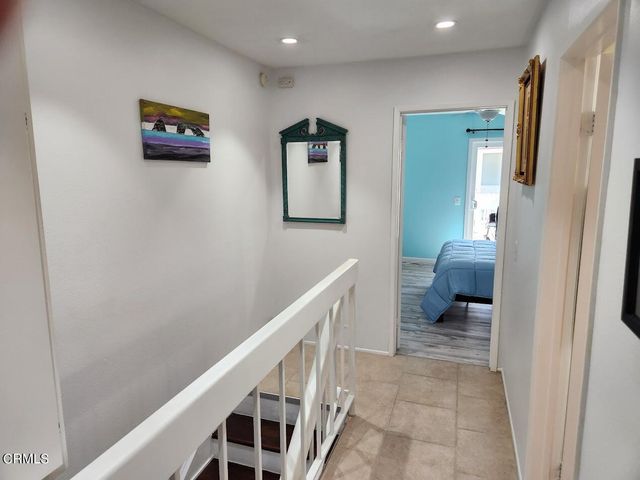 a hallway with a couch and a view of bathroom