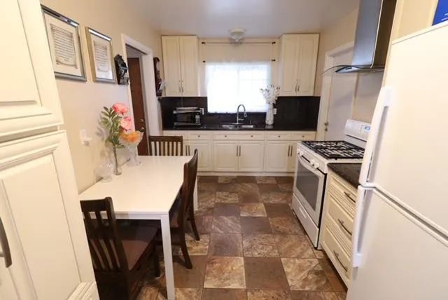 a kitchen with stainless steel appliances a stove a sink and a refrigerator