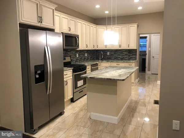 a kitchen with stainless steel appliances granite countertop a stove a refrigerator and a sink