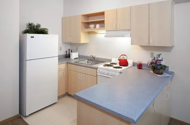 a kitchen with a refrigerator and white cabinets