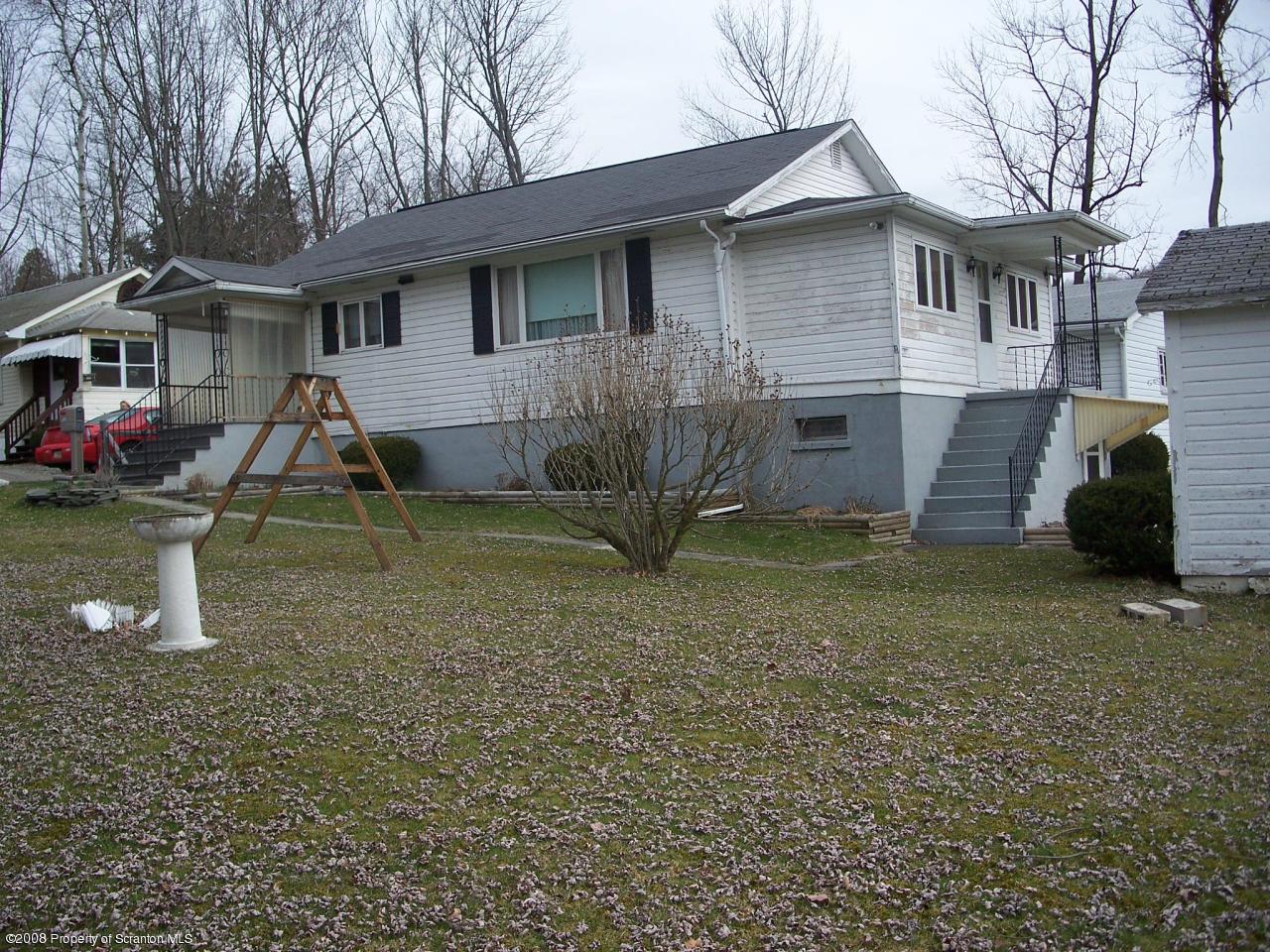 a view of a house with backyard and a tree