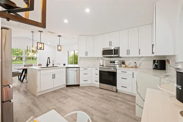 a kitchen with white cabinets and white appliances