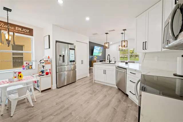 a kitchen that has a lot of cabinets a sink and appliances in it