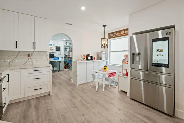 a room with furniture a flat screen tv and a refrigerator