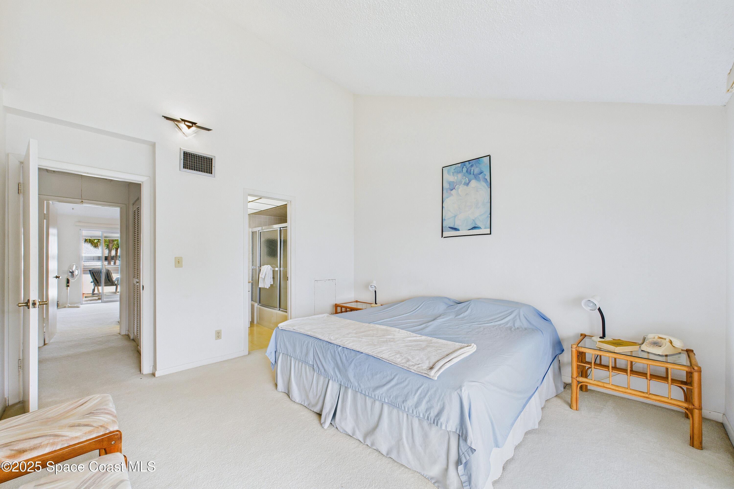 21 Cove Road, Unit 21E Melbourne Beach, FL 32951 - Photo 14 of 30 a bedroom with a bed and a couch