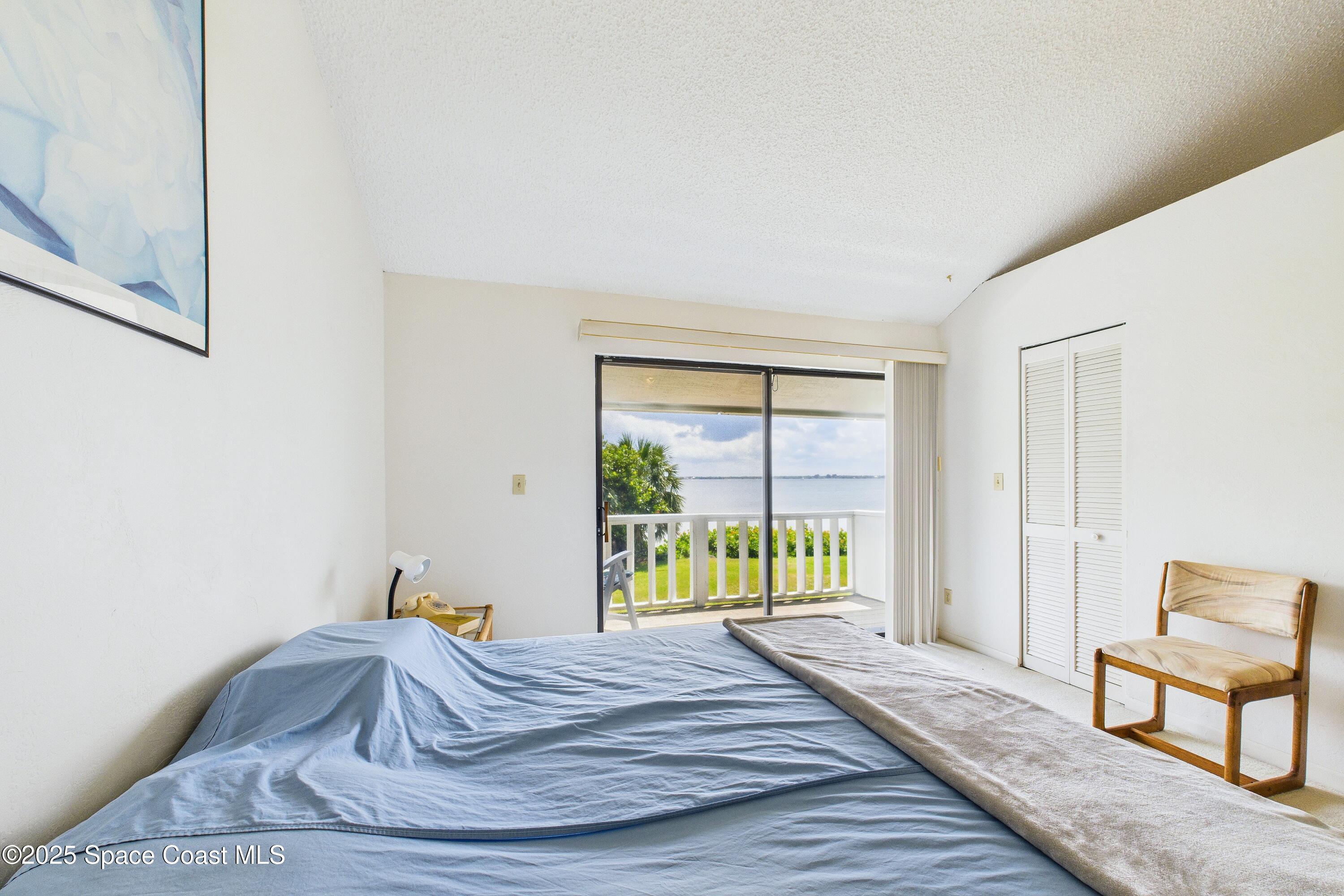 21 Cove Road, Unit 21E Melbourne Beach, FL 32951 - Photo 15 of 30 a bedroom with a bed and a window