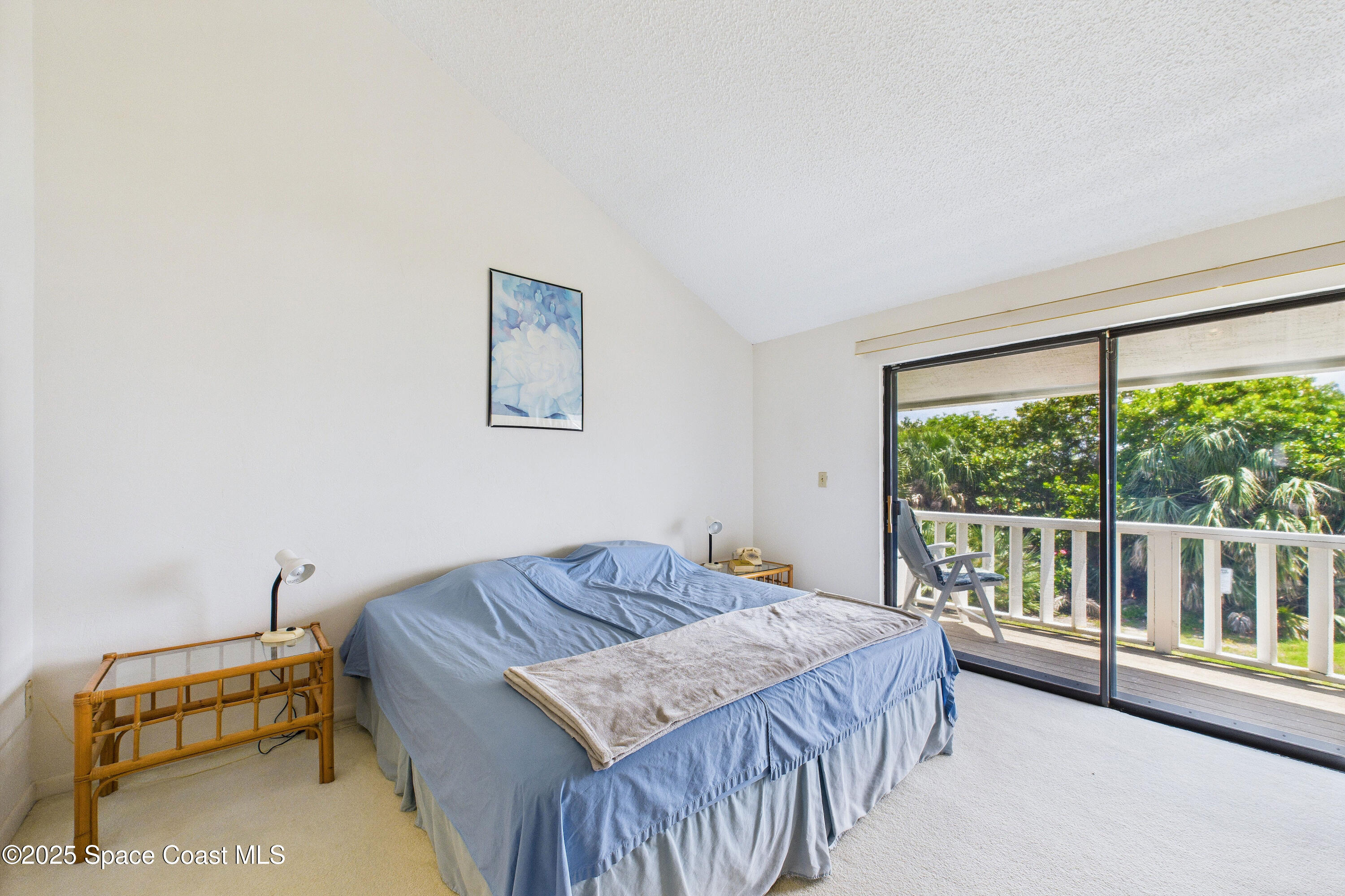 21 Cove Road, Unit 21E Melbourne Beach, FL 32951 - Photo 16 of 30 a bedroom with a bed and a couch