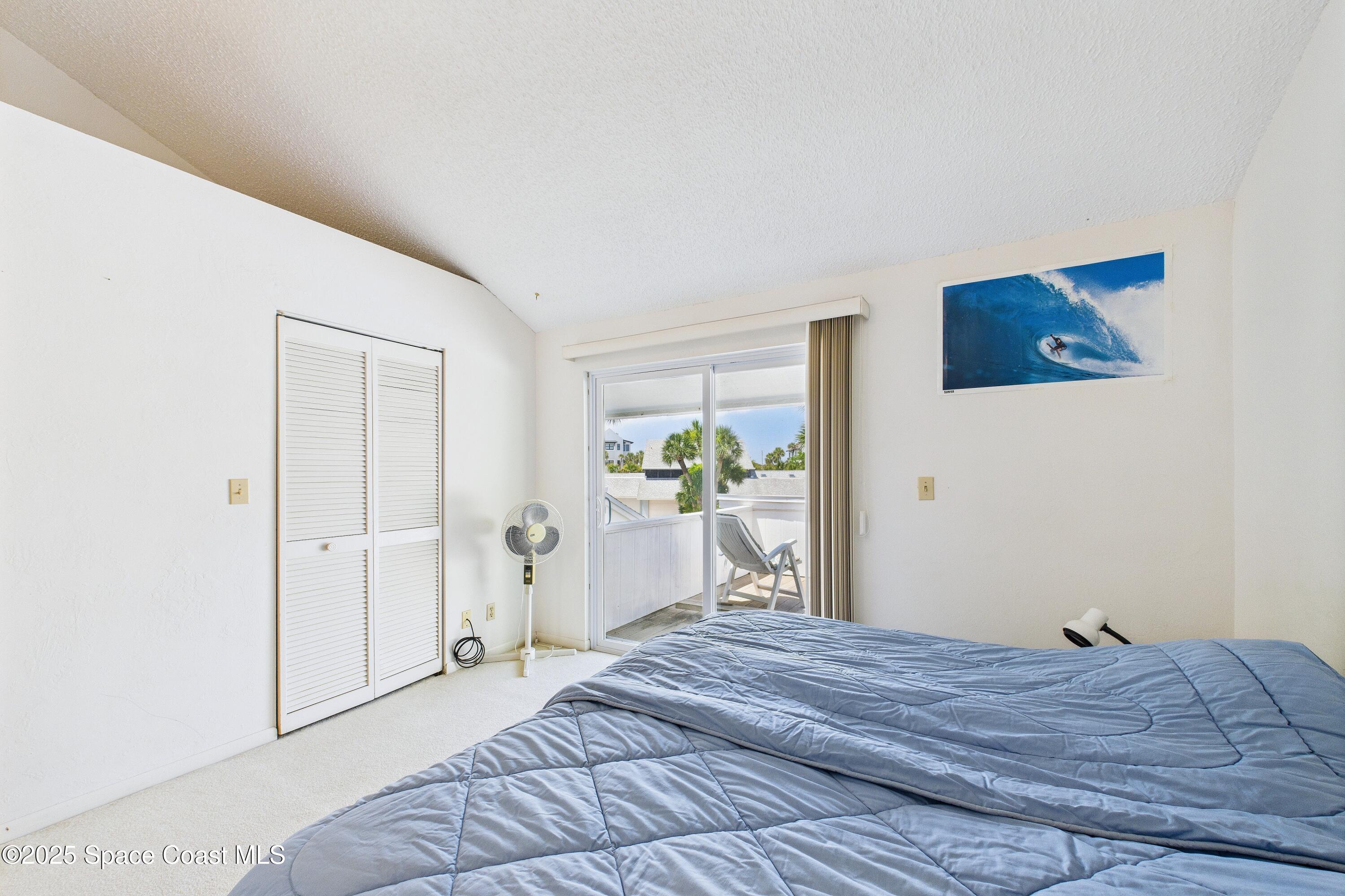 21 Cove Road, Unit 21E Melbourne Beach, FL 32951 - Photo 20 of 30 a bedroom with a bed and a painting on the wall
