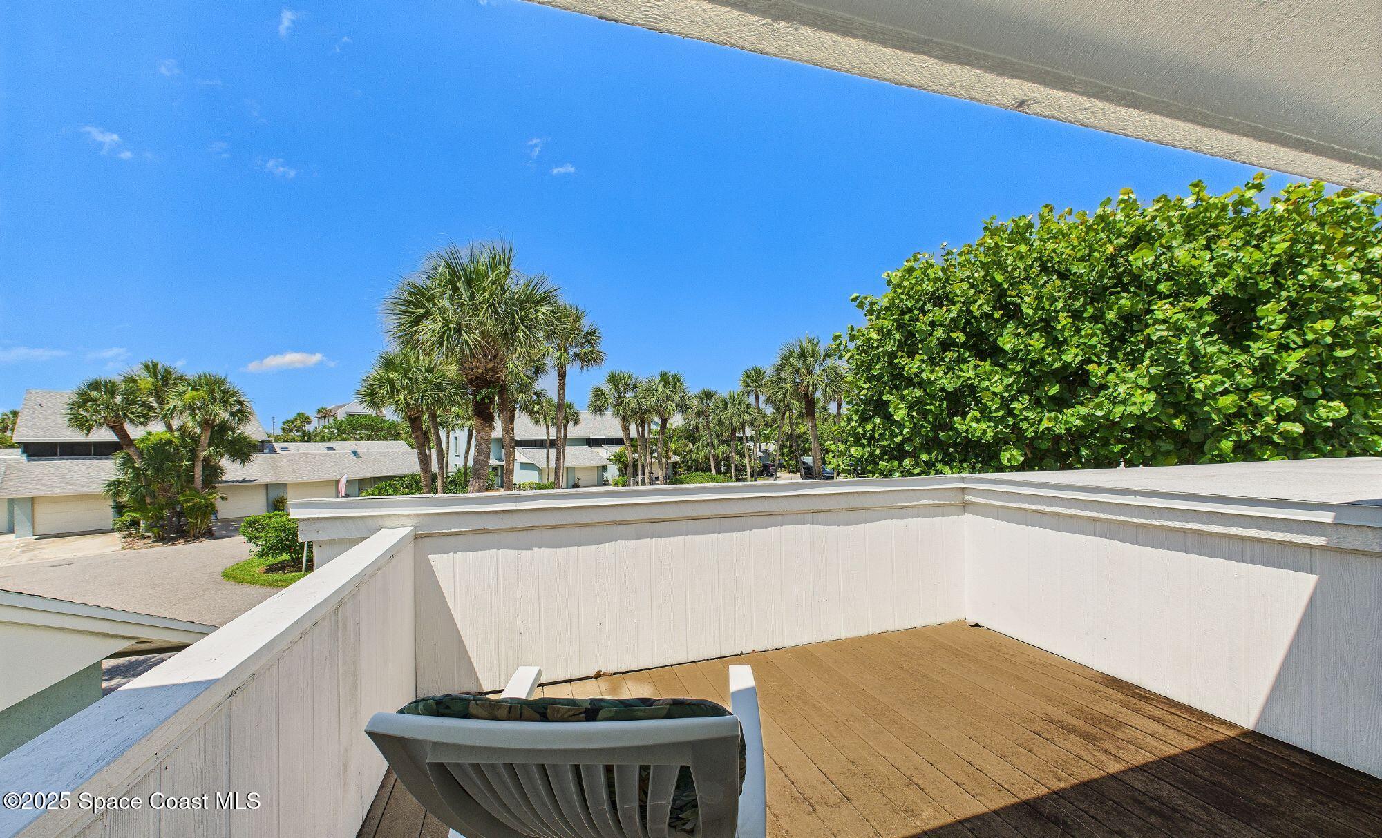 21 Cove Road, Unit 21E Melbourne Beach, FL 32951 - Photo 21 of 30 a view of a balcony with chair and wooden floor