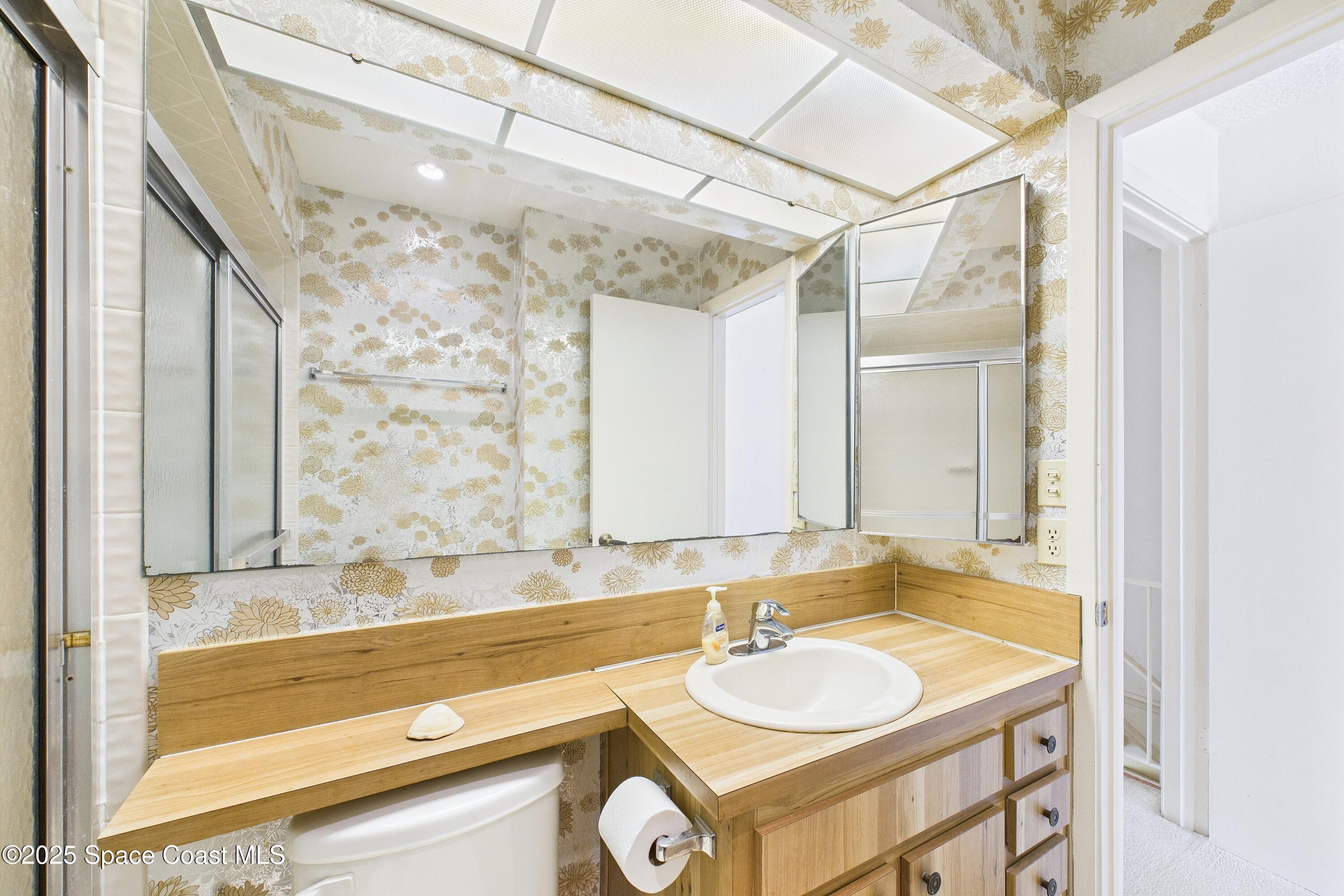 21 Cove Road, Unit 21E Melbourne Beach, FL 32951 - Photo 22 of 30 a bathroom with a granite countertop sink and a mirror